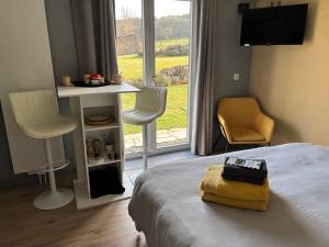 a bedroom with a bed and a table and chairs at La Milardière Chambres d'Hôtes in Theux