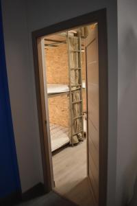 una porta che conduce a una stanza con un armadio con letti a castello di SLEEP STUDIO Hostel a Yerevan