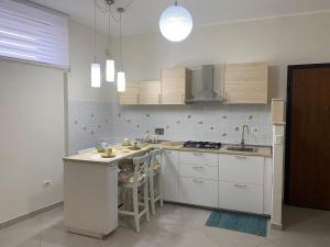 a kitchen with white cabinets and a stove top oven at La Terrazza di Finuzzu in Rende