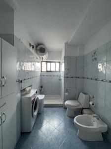 un bagno con due WC, un lavandino e una vasca di At Teo's a Durrës