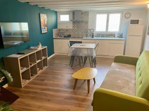 a kitchen and living room with a couch and a table at Charmant Loft in Cluses