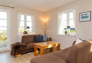 ein Wohnzimmer mit einer Couch und einem Tisch in der Unterkunft Ferienwohnung Lachmöwe in Norddorf