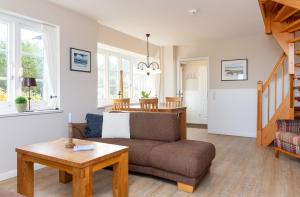 ein Wohnzimmer mit einer Couch und einem Tisch in der Unterkunft Ferienwohnung Lachmöwe in Norddorf