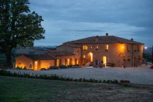 阿夏诺Agriturismo Mocine的一座大型石屋,前面有人坐在