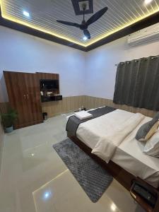 une chambre avec un lit et un ventilateur de plafond dans l'établissement Blackberry Resort Pushkar - Nature with Pool, à Pushkar