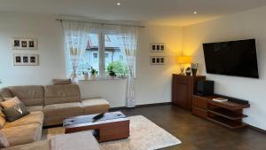 a living room with a couch and a flat screen tv at Moderne Wohnung in Achern, Schwarzwald in Achern