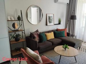 a living room with a couch and a round mirror at Stylish Modern 2BR in Waterfall Ellipse - Sleeps 4 - Fast WiFi - Secure Parking in Midrand