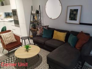 a living room with a couch and a table at Stylish Modern 2BR in Waterfall Ellipse - Sleeps 4 - Fast WiFi - Secure Parking in Midrand +31 photos