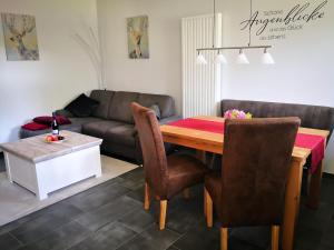a living room with a table and a couch at Auszeithof Otersen - Ferienwohnung 4 in Kirchlinteln