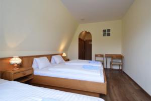 a bedroom with two beds with white sheets and a table at Hotel Restaurant Müllner in Marz +50 photos