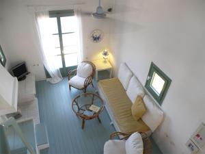 a living room with a white couch and a chair at Spitakia in Vourkari