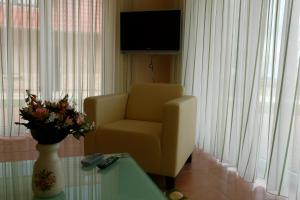 a living room with a chair and a table and a television at Ferienhaus direkt an See & Strand in Göhren-Lebbin