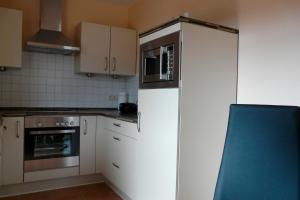 a kitchen with a white refrigerator and a microwave at Ferienhaus direkt an See & Strand in Göhren-Lebbin