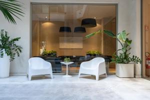 two white chairs and a table in a lobby at Home 15 Residence Hotel in Catania
