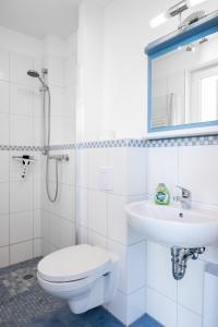 a white bathroom with a toilet and a sink at C 1 Ferienhaus MAJA in Gramkow