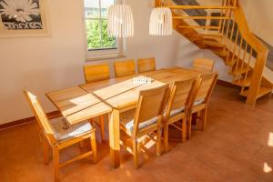 a dining room with a wooden table and chairs at C 1 Ferienhaus MAJA in Gramkow +16 photos