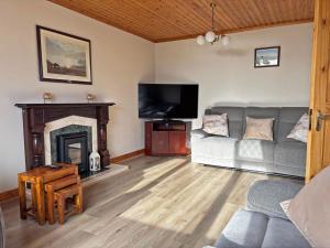 un salon avec un canapé et une cheminée dans l'établissement Cottage 467 - Kilkerrin, à Ardmore