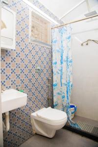 a bathroom with a toilet and a shower at Mamalla Kudil Resort in Mahabalipuram