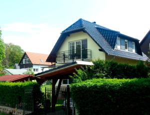 a house with a blue roof and a fence at Ferienhaus am Fleesensee in Göhren-Lebbin