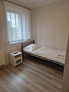 mała sypialnia z łóżkiem i oknem w obiekcie Restauracja i Noclegi Pod Sikorką w mieście Kobior