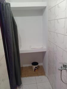 洛美After Labour的带淋浴帘和架子的浴室