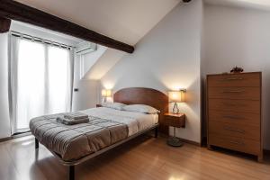ミラノにあるMilanRentals - Palazzi Apartmentのベッドルーム1室(ベッド1台、ドレッサー、窓付)