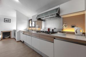 cocina grande con encimeras blancas y fogones en MilanRentals - Palazzi Apartment, en Milán