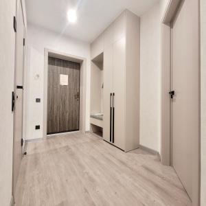 an empty hallway with a door and wooden floors at ApartPoltava Перлина біля Мюнхена РЕМОНТ 2025 in Poltava