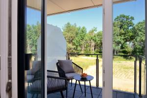 Zimmer mit einem Balkon mit einem Stuhl und einem Tisch in der Unterkunft FeWo Prora - Gooddays in Binz