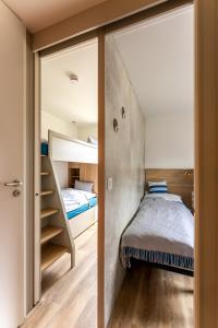 a small bedroom with a bunk bed and a staircase at Düne 46 in Scharbeutz