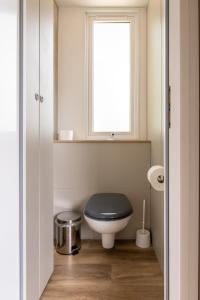 a bathroom with a toilet with a black seat and a window at Düne 46 in Scharbeutz