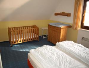 a bedroom with two twin beds and a crib at Ferienhaus an der Müritz in Rechlin