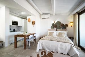 a bedroom with a bed and a table and a dining room at Appartamento Domo de oro in Baja Sardinia