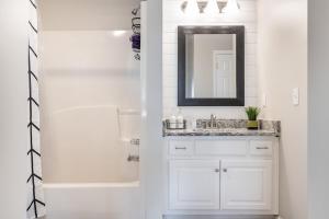 a white bathroom with a sink and a mirror at Stylish and Cozy Retreat in Buford +53 photos