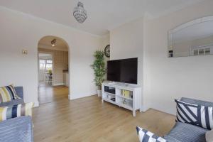 スタンウェルにあるModern 4 bedroom house in Heathrow, Londonのリビングルーム(テレビ、ソファ付)