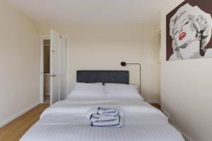 スタンウェルにあるModern 4 bedroom house in Heathrow, Londonのベッドが2つあり、壁に絵が飾られた寝室