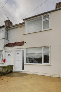 スタンウェルにあるModern 4 bedroom house in Heathrow, Londonの白いドアと窓のある白い家