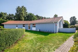 une maison bleue avec une clôture et une cour dans l'établissement Hus Lykke - Strandpark 38, à Grömitz