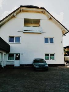 a car parked in front of a white house at 76 qm Whg im EG Haus-Wohlfühloase vor der Haustür in Gladenbach