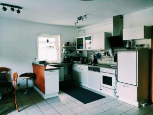 a kitchen with white appliances and a window at 76 qm Whg im EG Haus-Wohlfühloase vor der Haustür in Gladenbach +4 photos