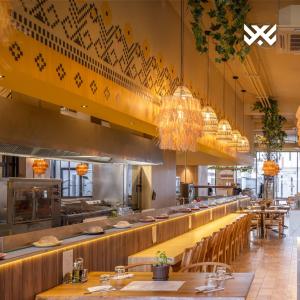 a restaurant with a long counter with tables and chairs at Presidental Suite in Luxury Hotel at City Center in Pristina