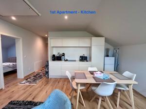 a kitchen and dining room with a table and chairs at Cozy Apartment near Vienna Airport in Schwechat