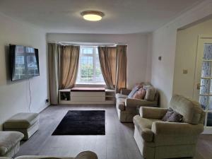a living room with two couches and a window at Nicely decorated 3 bedroom house near Heathrow, London in London