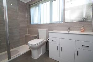 a bathroom with a toilet and a sink and a shower at Nicely decorated 3 bedroom house near Heathrow, London in London +28 photos