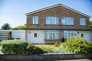 a brown brick house with a white garage at Nicely decorated 3 bedroom house near Heathrow, London in London