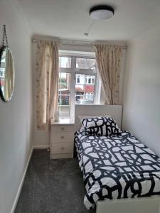 a bedroom with a bed and a window at Nicely decorated 3 bedroom house near Heathrow, London in London