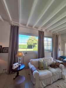 a living room with a white couch and a window at Les Suites de Marie-Lot in Vire-sur-Lot +54 photos