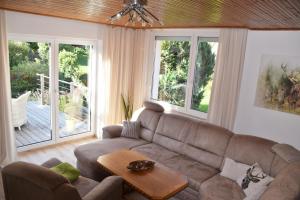 a living room with a couch and a table at Superior - Ferienhaus am Engelsbach mit Garten und Pool in Engelsbach