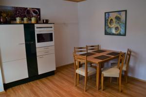 cocina con mesa pequeña y cocina con nevera en Superior - Ferienhaus am Engelsbach mit Garten und Pool, en Engelsbach 16 fotos más