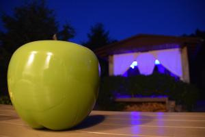 a green apple sitting on a table in front of a house at Superior - Ferienhaus am Engelsbach mit Garten und Pool in Engelsbach